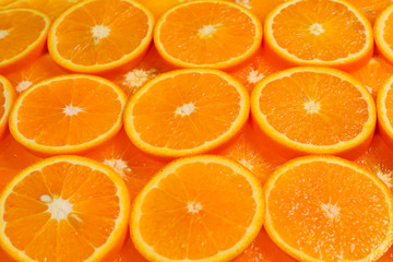 Slices of oranges as a background, top view.