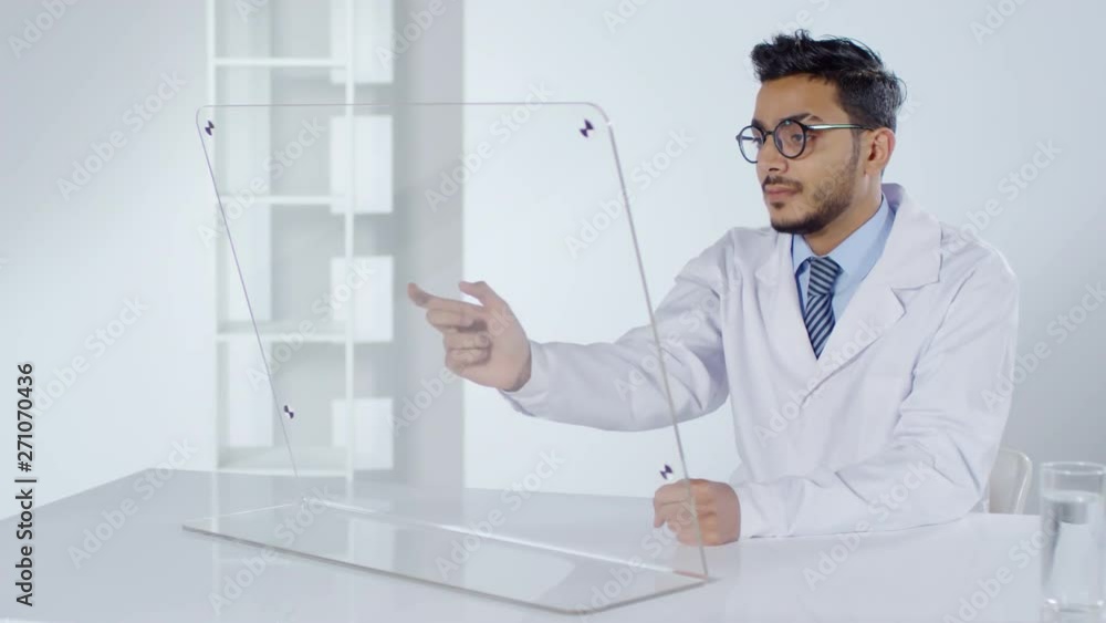 Aufkleber lockdown of arab male doctor in lab coat swiping on transparent monitor of futuristic computer while