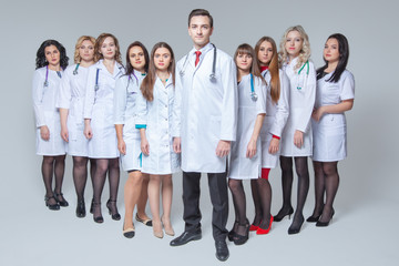 Full length portrait of an attractive male doctor staying at the head of group of doctors