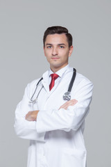 Male doctor with stethoscope standing and looking at camera