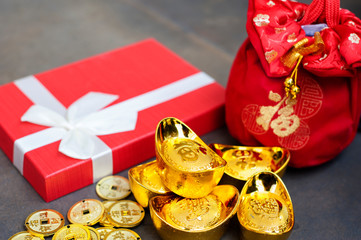 New Year Gift, red pouch money bag, Chinese gold coins and gold ingots with Chinese character meaning whealth, rich, gold, luck, healthy.