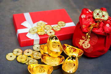 New Year Gift, red pouch money bag, Chinese gold coins and gold ingots with Chinese character meaning whealth, rich, gold, luck, healthy.