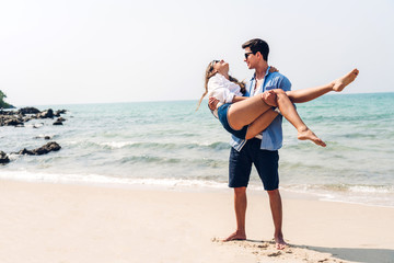 Romantic lovers young couple relaxing together on the tropical beach.Man hugging with woman and enjoy life.Summer vacations