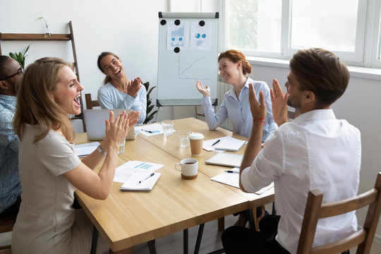 Diverse office workers team laughing and applauding at funny joke