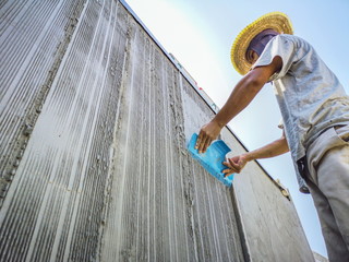 Creating a pattern on the wall.Workers are plastering the walls of the building. construction...