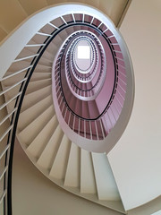 Spiral stairs winding upwards towards skylight