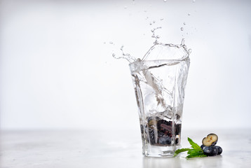 Splash into glass of infused water with berries and mint