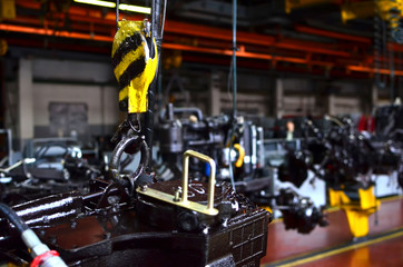 Bridge lifting Crane Hook against the background of the Assembly Line industrial factory. The...
