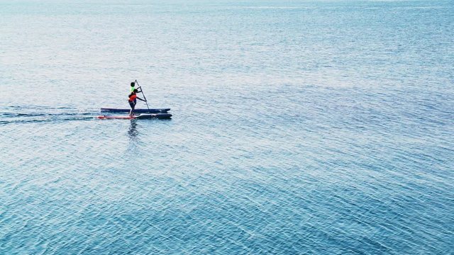 Sportsman rower on a kayak. Sunny day. People do sports. People ride on boats. People rowing oars standing on the boat. Sportsman rower on boat. Extreme sport. 