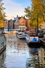 Papier Peint photo Amsterdam Amsterdam Pays-Bas maisons dansantes sur la rivière Amstel monument dans le vieux paysage de printemps de la ville européenne.