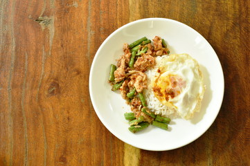 Fototapeta na wymiar spicy stir fried pork with yard long bean curry topping egg on rice