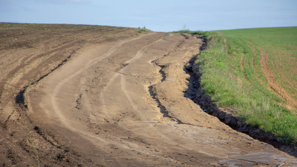 Fototapeta na wymiar Agrarian fields after heavy rain, deposits of chernozem and various debris on the field.