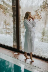 Fototapeten Pretty woman in bathrobe.standing  by the pool in the spa © BGStock72