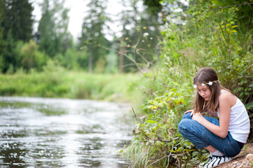 Pretty young girl discovering the nature at river coast