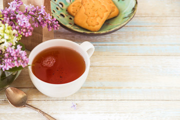 Tea and blooming lilac, petal in a cup