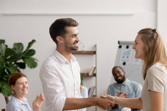 Young employee encouraging for good project results handshaking with director