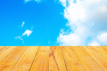 Old Wooden table with blue sky white cloud background.