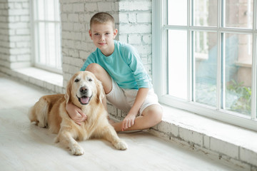 A boy with a dog at home.