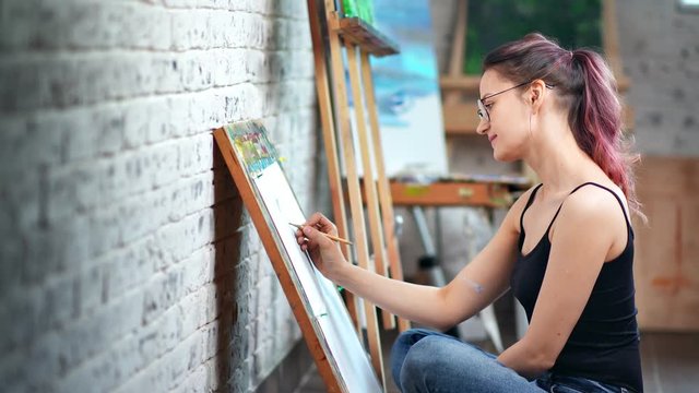 Beautiful casual female illustrator painting sketch using gray pencil at art workshop studio