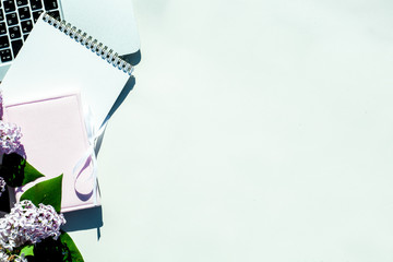 Flat lay on a white background composition with tender flowers of lilac , pale pink box with a...