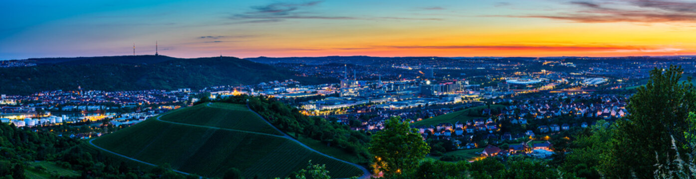 Germany, XXL landscape panorama of illuminated skyline of downtown city stuttgart at sunset from above in summer