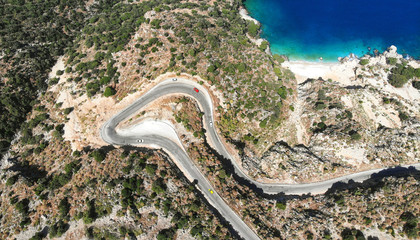 Aerial serpentine road. Traffic motion on a  mediterranean road in the mountains by the sea. Trip by car. Top view.