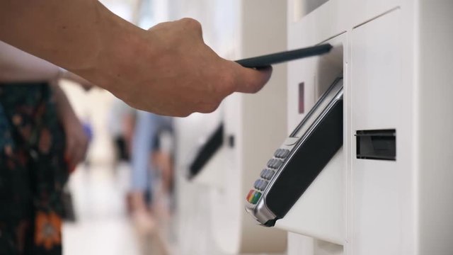a young man buys a telephone in a contactless way in a self-service machine. men pay by phone. close up