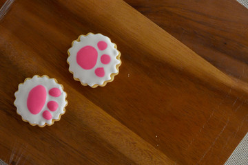 Cat footprints Cookies with icing on wooden table.