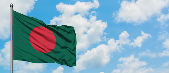 Bangladesh flag waving in the wind against white cloudy blue sky. Diplomacy concept, international relations.