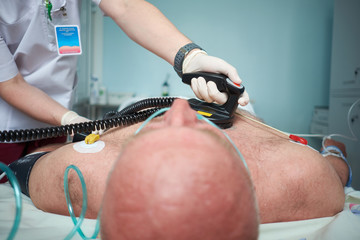 Doctor intensivist performs defibrillation to critical patient