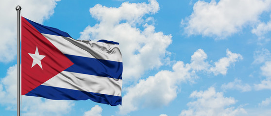 Cuba flag waving in the wind against white cloudy blue sky. Diplomacy concept, international relations.