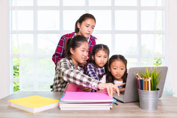 Student girls interest watching computer notebook together during study in the class, Back to school concept