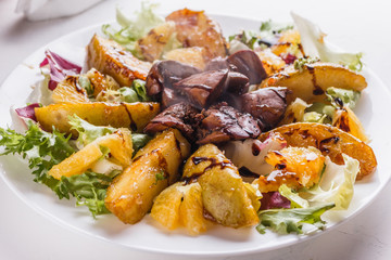 Baked potatoes with boiled chicken liver on a plate