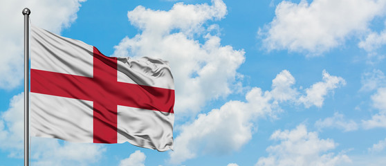 England flag waving in the wind against white cloudy blue sky. Diplomacy concept, international relations.
