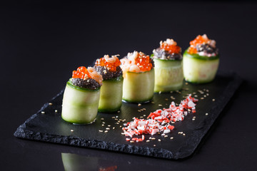 rolls covered in cucumber with caviar and prawn