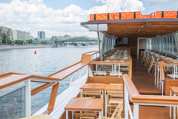Fototapeta premium The interior of the urban river ship, with a panoramic view of the urban landscape. The concept of tourism, recreation, walking around the city, rest in the city. River transport.