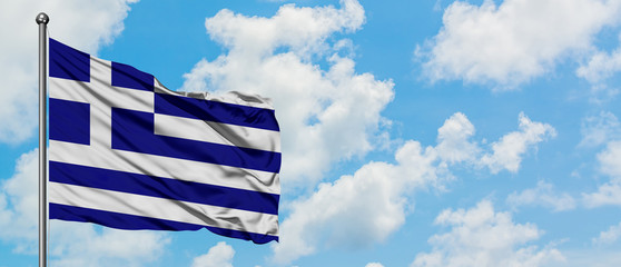 Greece flag waving in the wind against white cloudy blue sky. Diplomacy concept, international relations.