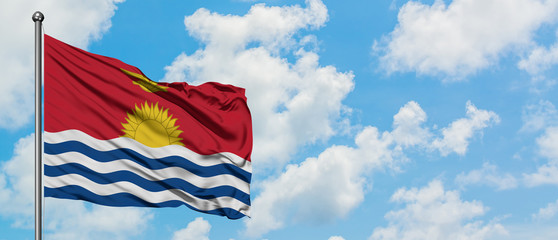 Kiribati flag waving in the wind against white cloudy blue sky. Diplomacy concept, international relations.
