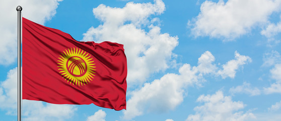 Kyrgyzstan flag waving in the wind against white cloudy blue sky. Diplomacy concept, international relations.