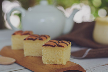 Cube cut of butter cake on wooden tray and table for served in party. Delicious dessert eat with tea and coffee in morning.