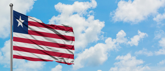 Liberia flag waving in the wind against white cloudy blue sky. Diplomacy concept, international relations.