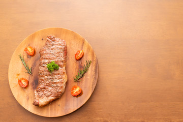 Fresh cooked sirloin beef steak with cherry tomato and rosemary on top with parsley, Wood background, Copy space on the right