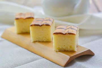 Cube cut of butter cake on wooden tray and table for served in party. Delicious dessert eat with tea and coffee in morning.