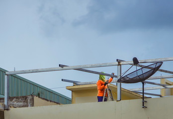 Worker welding the steel part for roof  before it is going to rain.