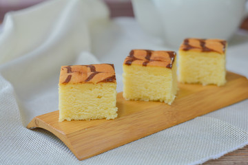 Cube cut of butter cake on wooden tray and table for served in party. Delicious dessert eat with tea and coffee in morning.
