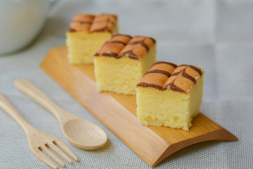 Cube cut of butter cake on wooden tray and table for served in party. Delicious dessert eat with tea and coffee in morning.