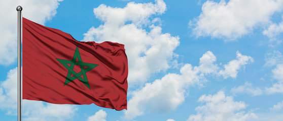 Morocco flag waving in the wind against white cloudy blue sky. Diplomacy concept, international relations.