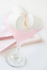 Marshmallows and bowl against white background