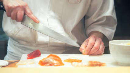 Obraz na płótnie Canvas Japanese chef making sashimi in kitchen
