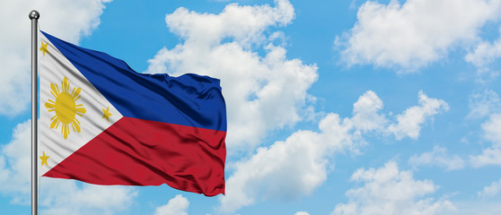 Philippines flag waving in the wind against white cloudy blue sky. Diplomacy concept, international relations.